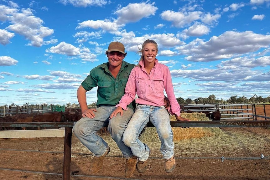 Maree and Rhiley Kuhrt sitting on fence smiling on rural property. 