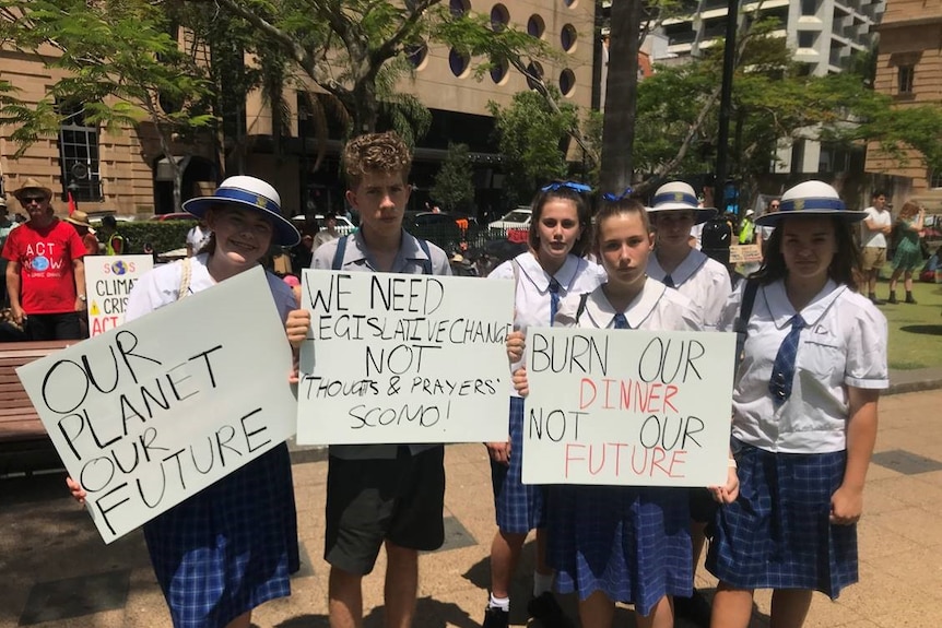 Six school students with signs outside