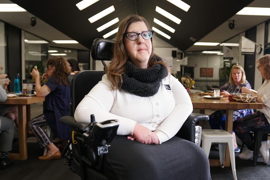 A woman in a wheelchair looks at the camera