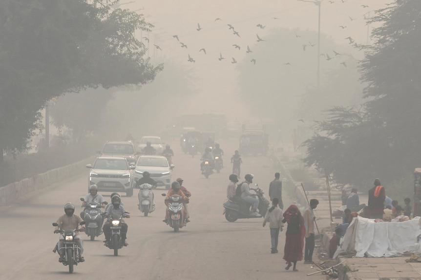 an early morning with vehicles, cars and motorbikes, on a road surrounded by smog