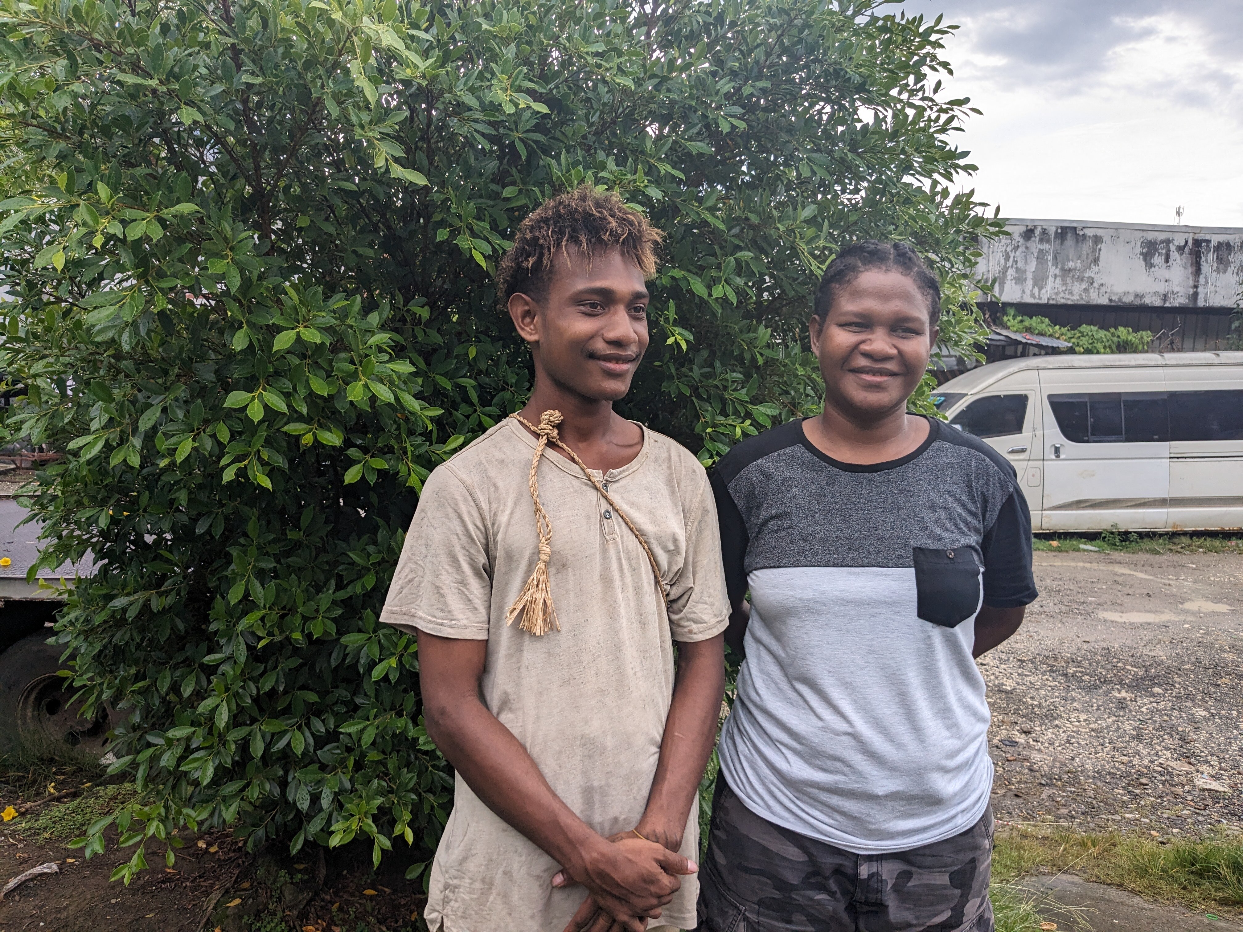 Woman and man stand outside smile to camera. 
