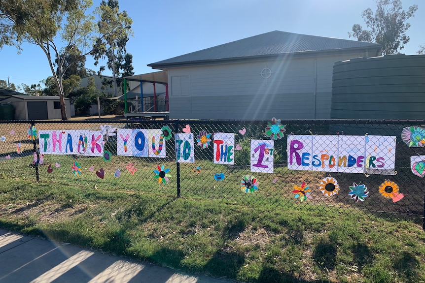 a colourful sign saying 'thank you to the 1st responders' created by children and hung from a school fence