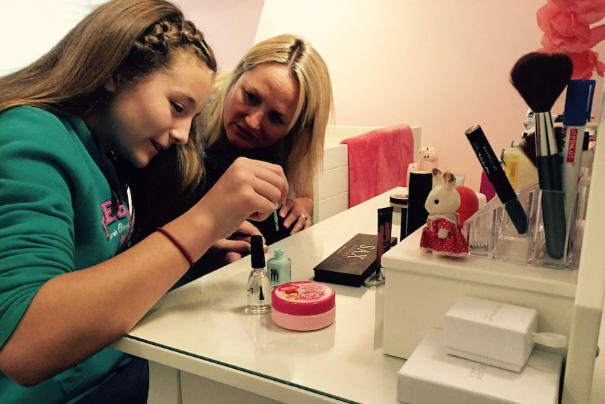 Mum and daughter paint nails in a bedroom