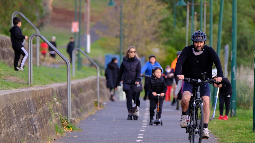 Group of city residents walking and cycling