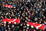 People carry the flag-draped coffins of police officers killed in Saturday's blasts in Istanbul.