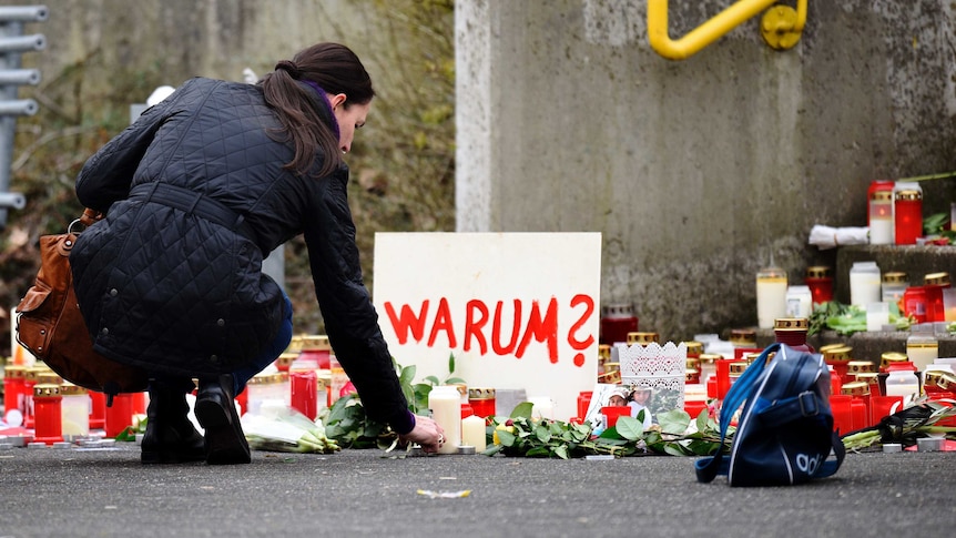 Woman lays flowers outside school in Germany