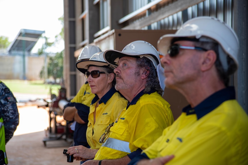 Workers in hard hats and high-vis at a water treatment plant.