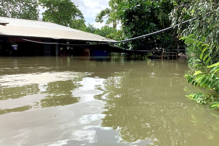 Murky water engulfs a home in a rural town