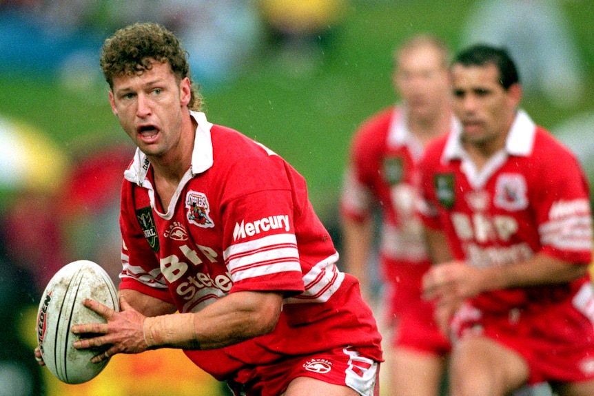 A man looks to pass during an NRL match