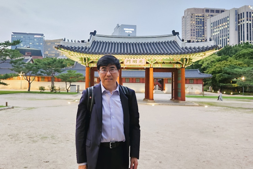 Man stands in front of chinese-style architecture