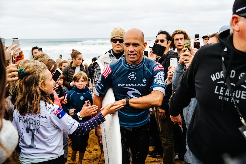 An American male surfer accepts congratulations from supporters at Bells Beach in 2019.