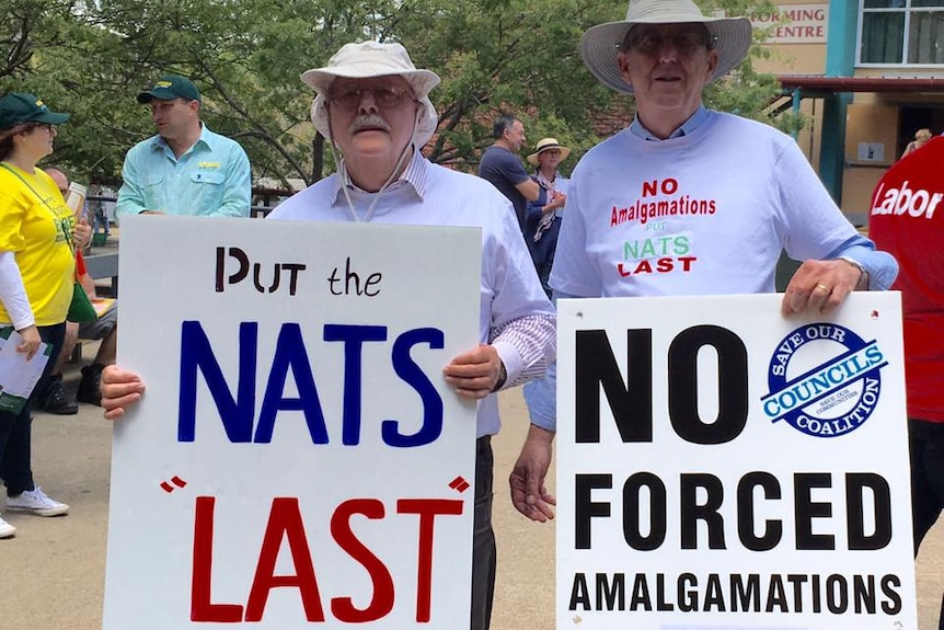 Save our Councils NSW campaigners hold signs saying "put the Nats last" and "No forced amalgamations".