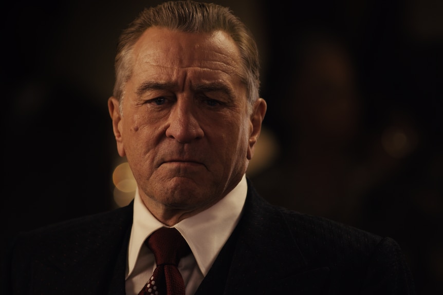 Robert De Niro looking serious in a suit in the film The Irishman