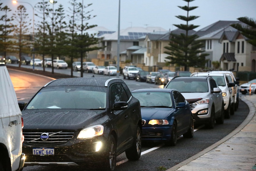 A queue of cars on the road in the rain.