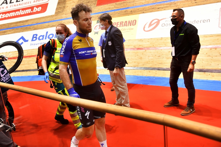 A cyclist walks inside a velodrome after being involved in a crash.