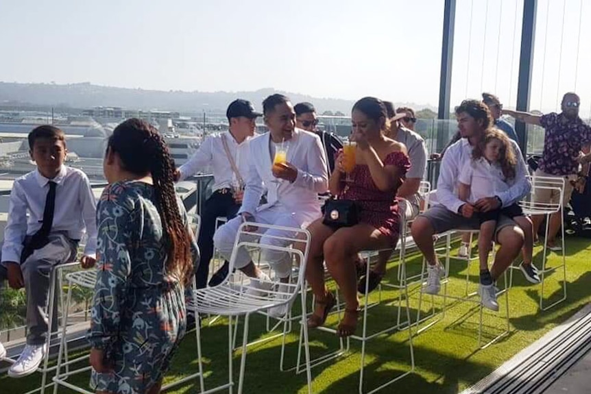 Wedding party of Chante and Jacob Ketu sits in chairs at the venue.