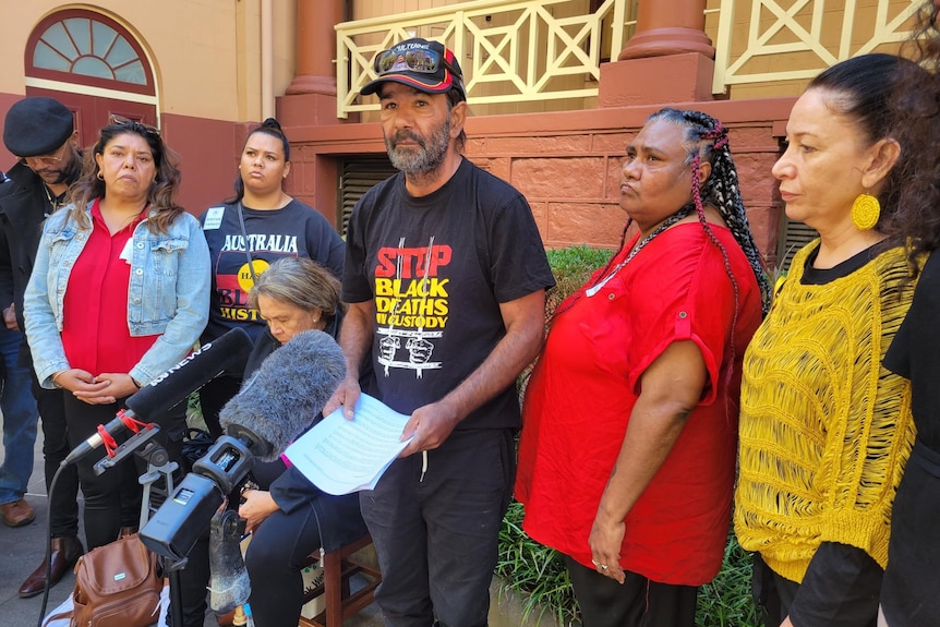 A group of people talk to the media