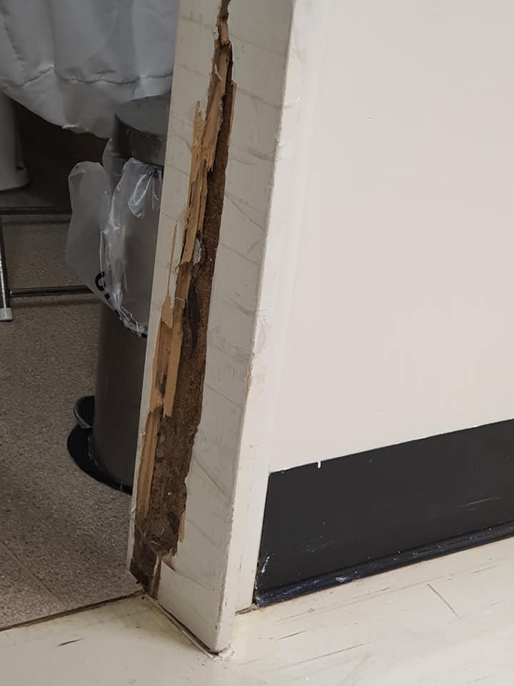a door frame has a large hole exposing the beams within