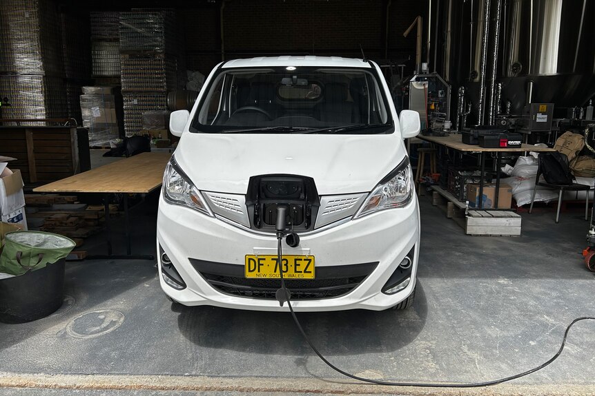 An electric van being charged in a garage.