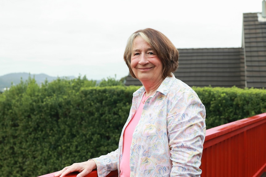 Frances Logan stands on a balcony.