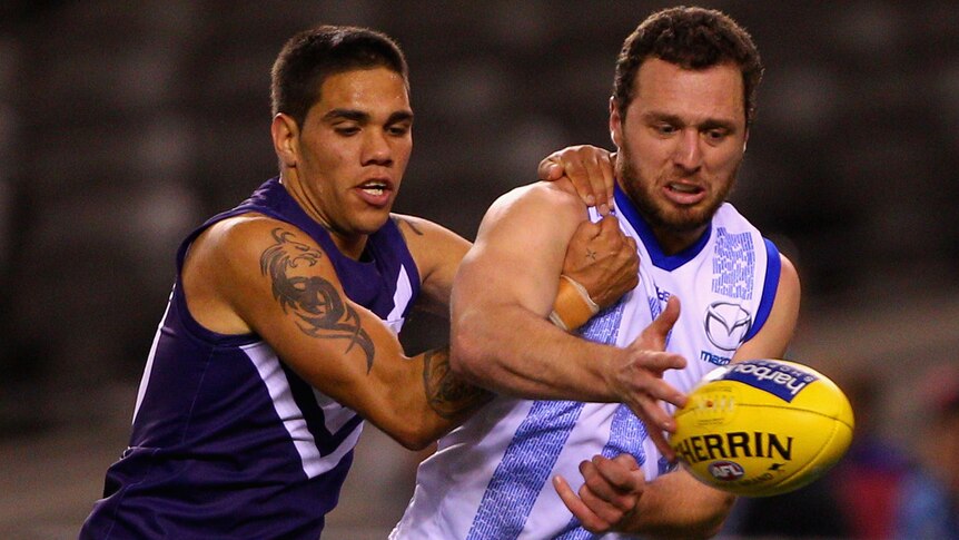 The Dockers' Michael Walters and the Kangaroos' Scott McMahon fight for possession at Docklands.