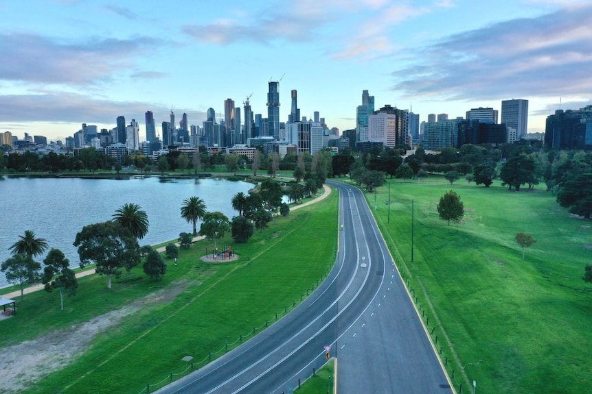 No traffic on the road around Albert Park Lake in Melbourne with the city skyline in the distance.