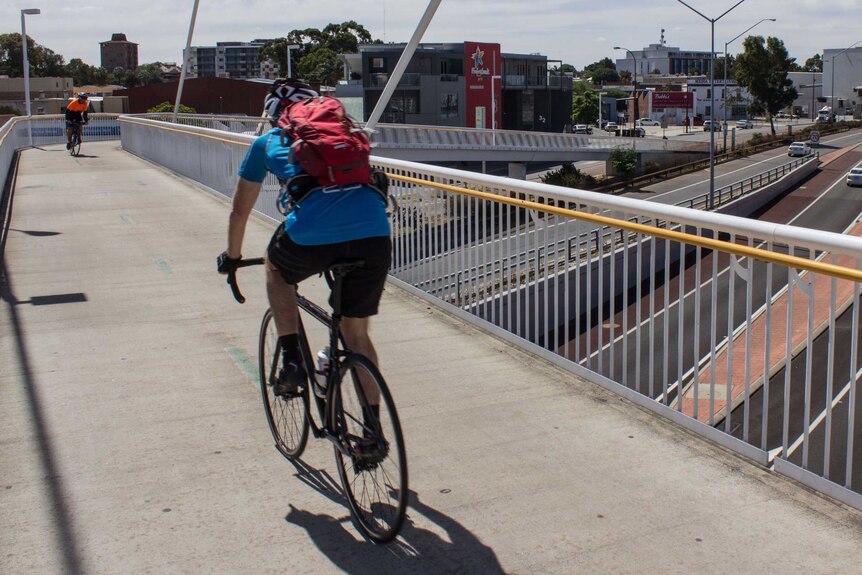 Two cyclists on a shared path at Claisebrook train station, above the Graham Farmer freeway in East Perth