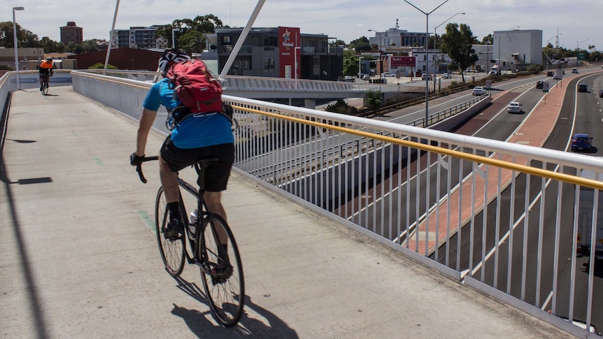 Two cyclists on a shared path at Claisebrook train station, above the Graham Farmer freeway in East Perth