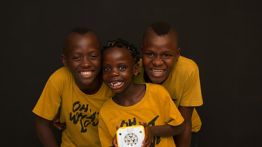 Children hold the Solar Buddy light.