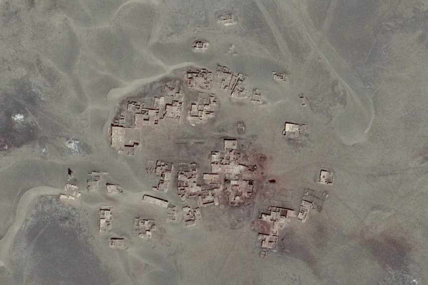 A compound of small buildings are seen in an aerial image