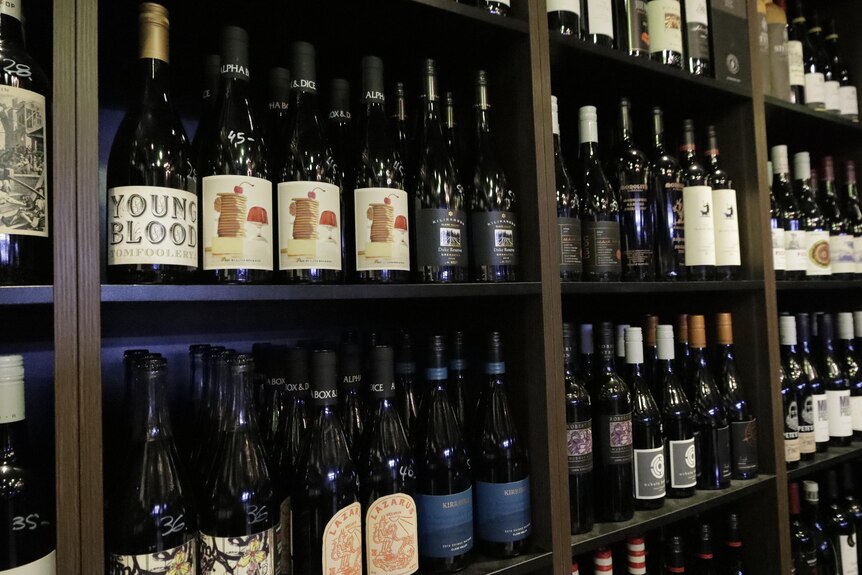 Shelf full of bottles of red wine