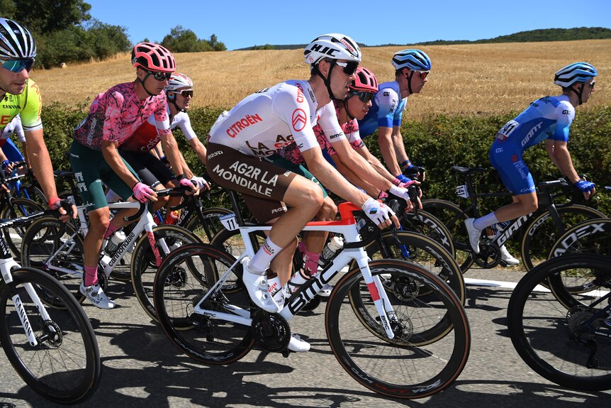 A cyclist in a white jersey rides in the peloton during a stage of the Vuelta.