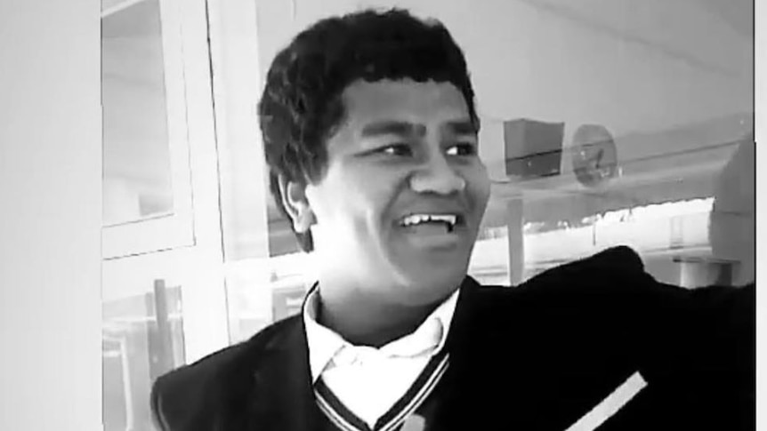 A black and white photo of a teenage boy in a school uniform.