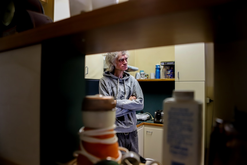 Man with grey jumper and grey hair looks directly into camera.