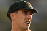 An Australian male Test cricketer looks to his left during a match.