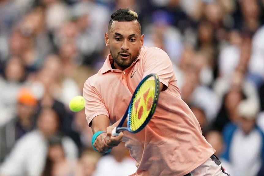 A male tennis player uses a double-fisted backhand return at the Australian Open.