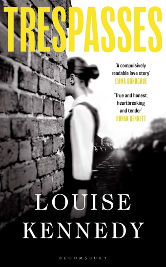 The book cover of Trespasses by Louise Kennedy, a black and white image of a girl walking behind a brick wall
