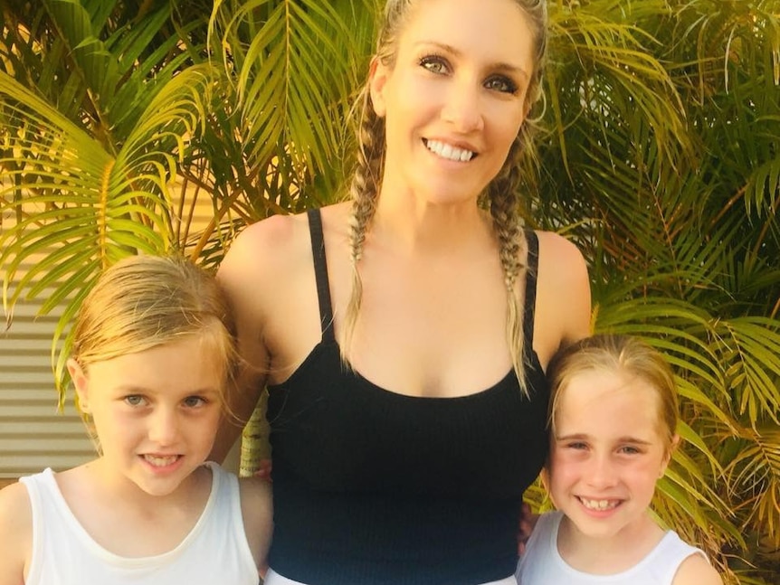 A blond woman with two smiling girls.