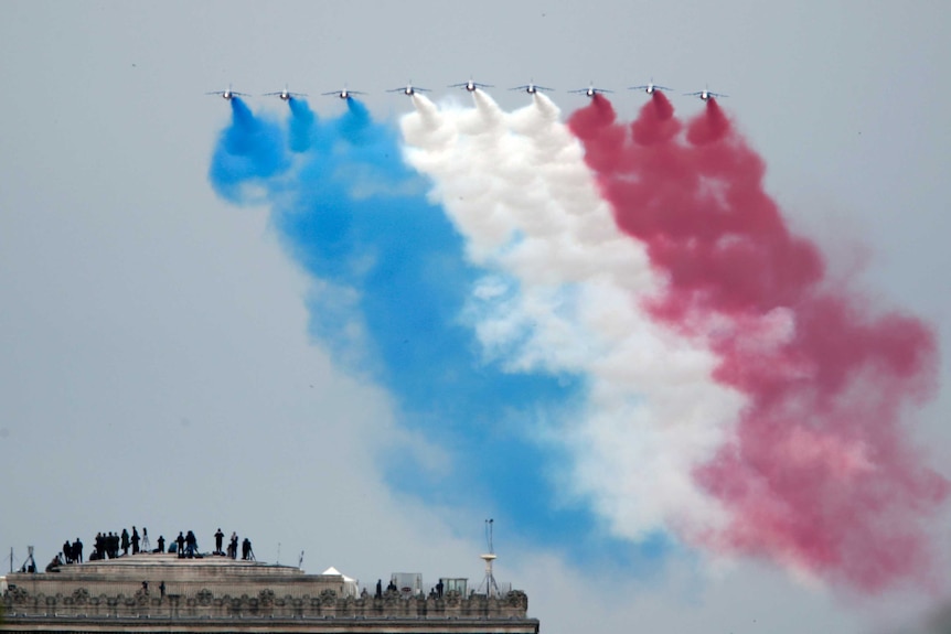 Guests watch an air show from the top of the Arc de Triomphe in Paris.