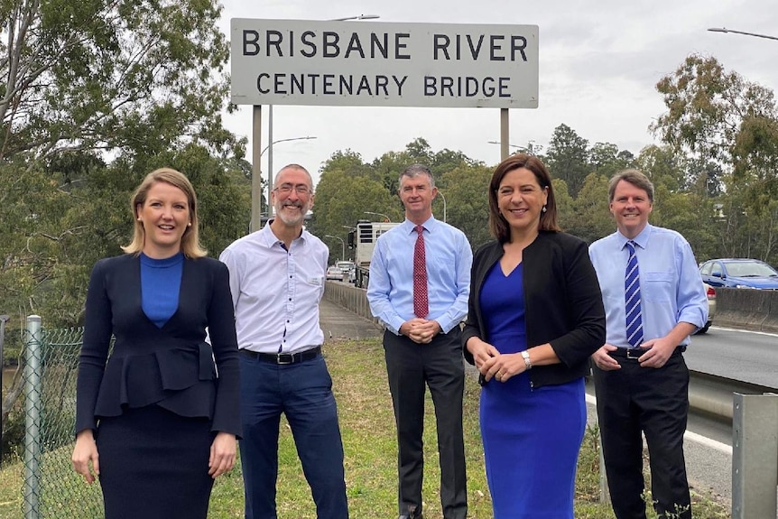 LNP members and candidates pose under sign saying 'Centenary Bridge'.