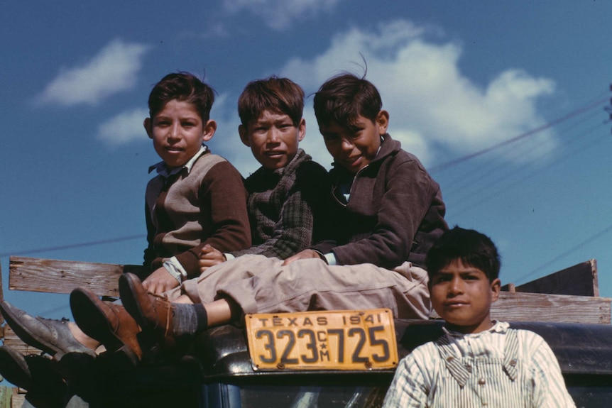 Boys sit on a truck at the Farm Security Administration in Robstown, Texas, 1942.