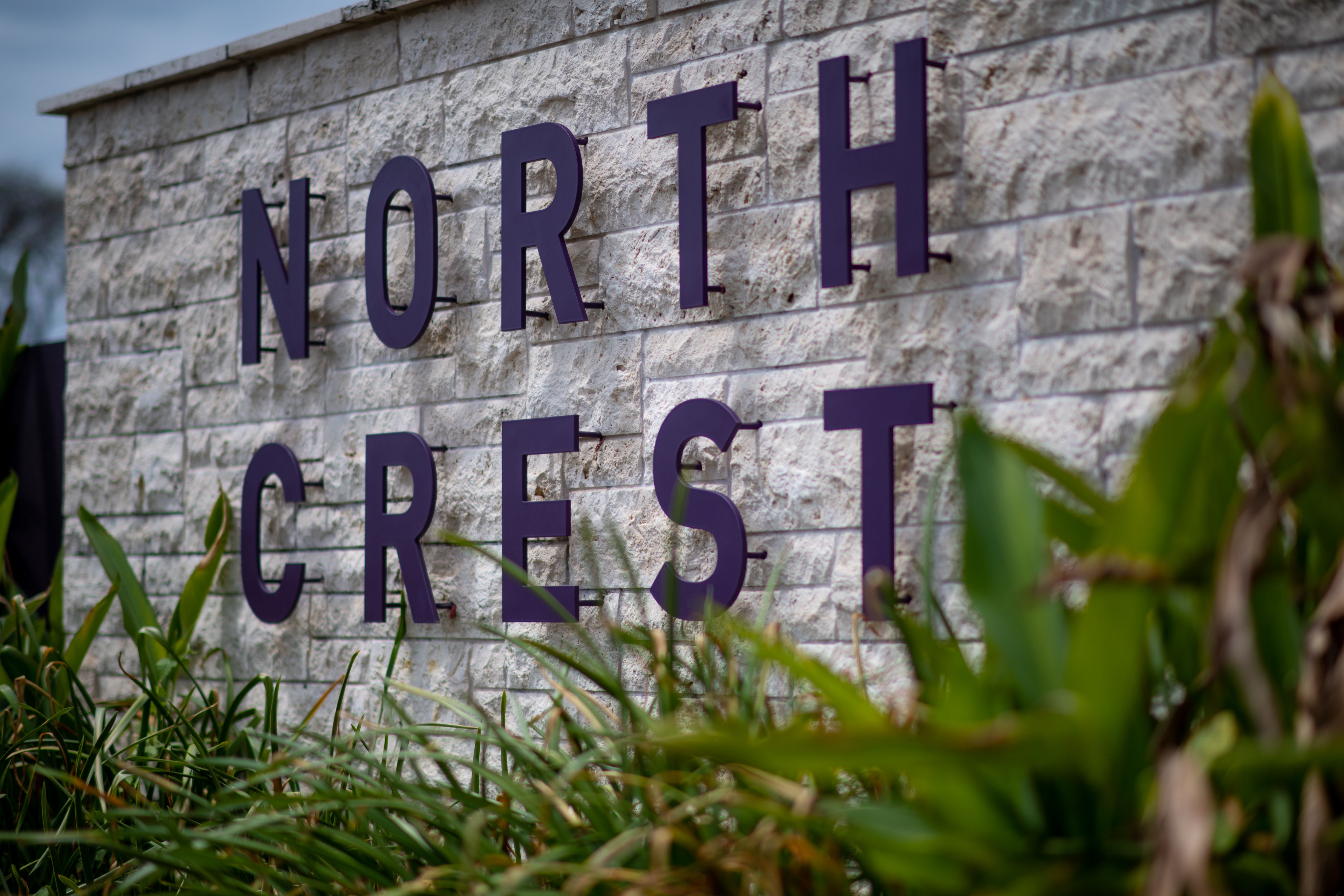 The words "Northcrest" are displayed on a white brick wall in navy.