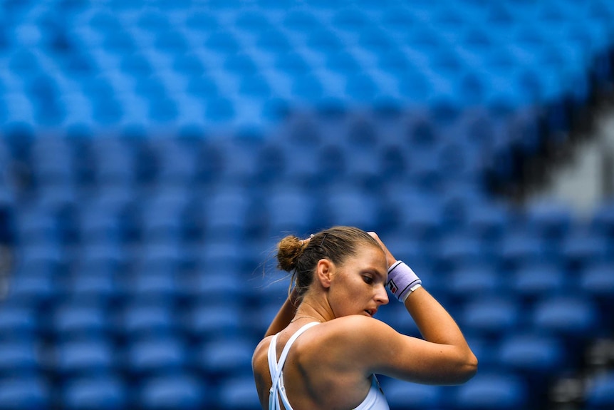 Karolína Plíšková stands in front of an empty grandstand