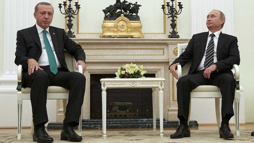 Russian President Vladimir Putin and Turkish President Recep Tayyip Erdogan are seated in room