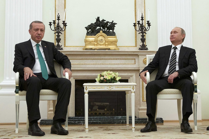 Russian President Vladimir Putin and Turkish President Recep Tayyip Erdogan are seated in room