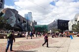 People walk through Federation Square in Melbourne.