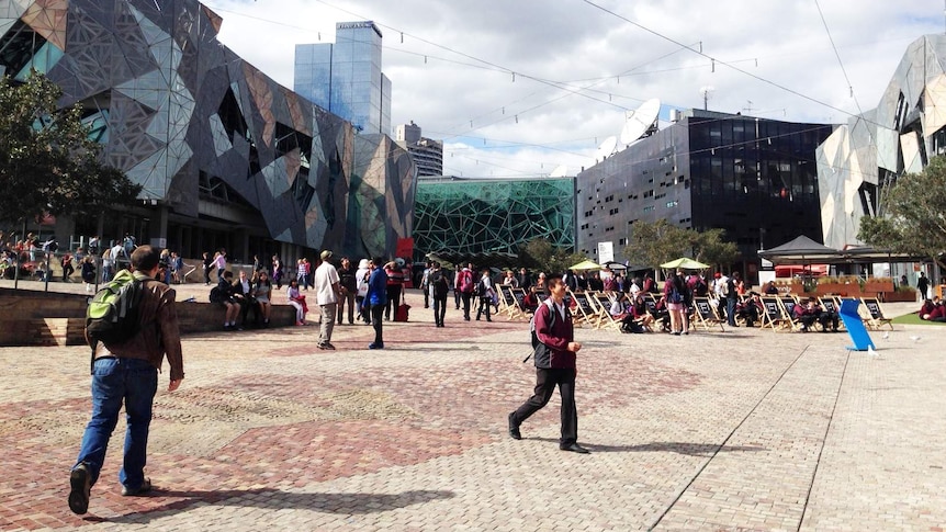 People walk through Federation Square in Melbourne.