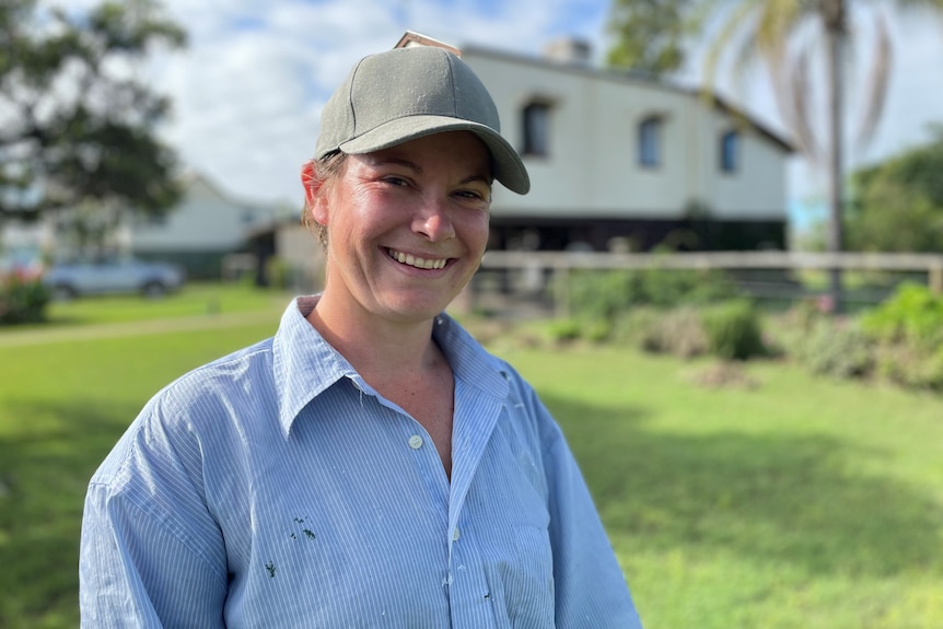 A woman with a cap on smiling. 