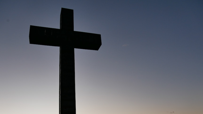 20-metre tall crucifix silhouetted against dusk-lit sky