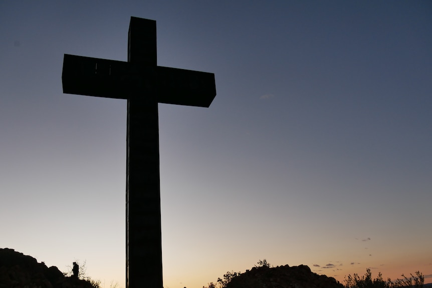 20-metre tall crucifix silhouetted against dusk-lit sky